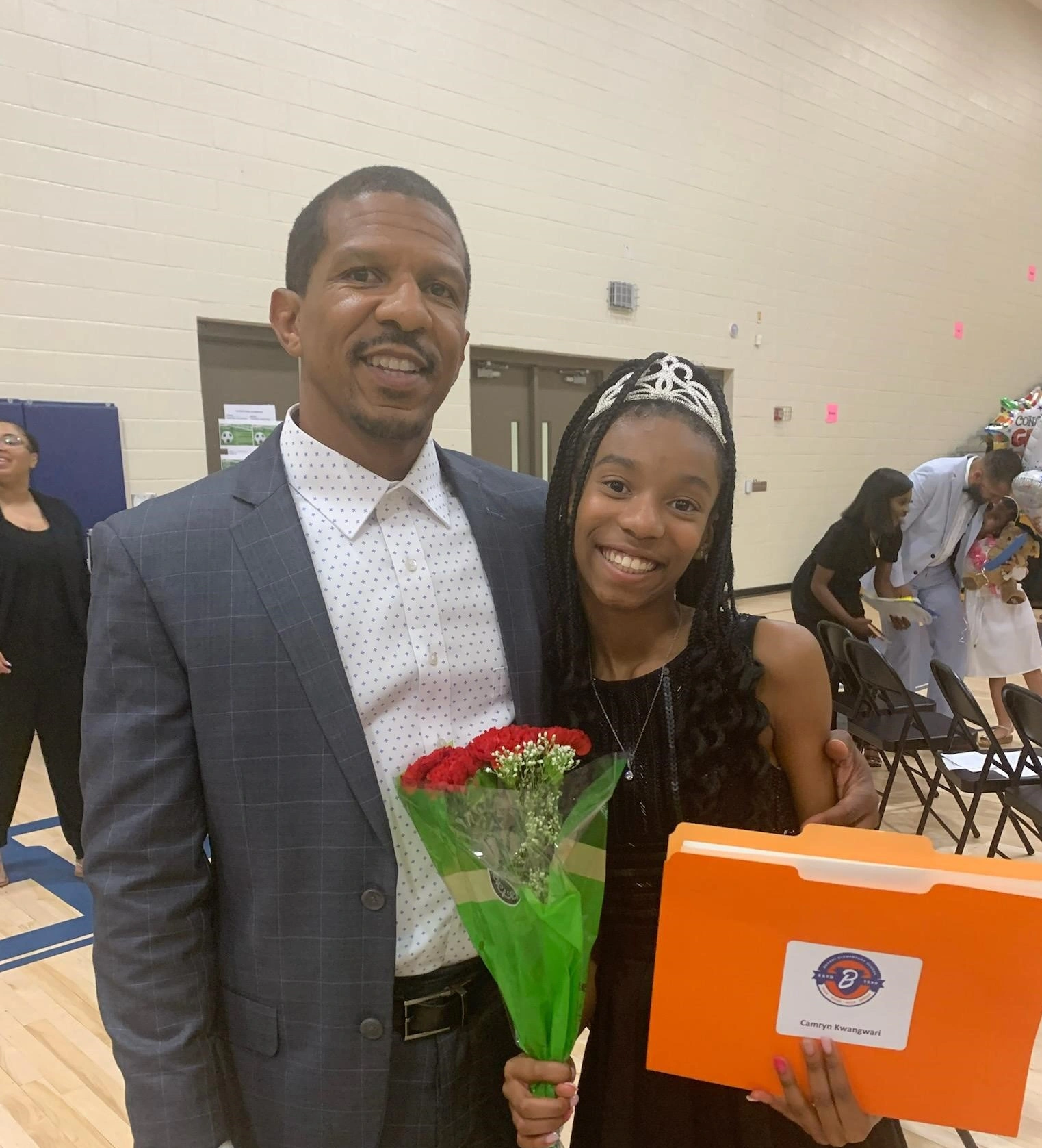 Celebration of a young girl with her father holding flowers and a folder